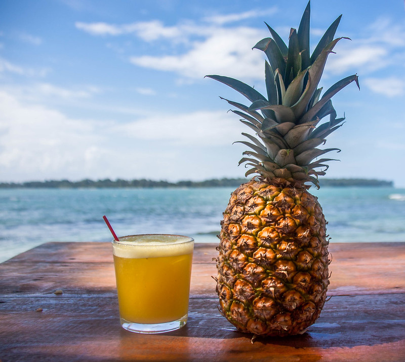 A pina colada next to an uncut pineapple