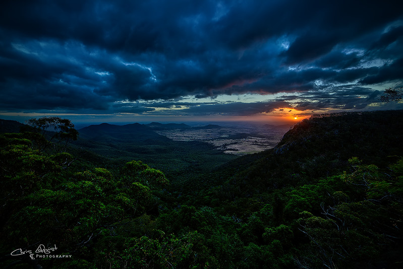 High view over a rainforest at sunset with storm clouds